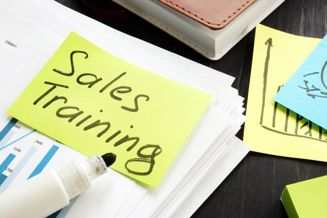 Sales training sign and business report with charts.